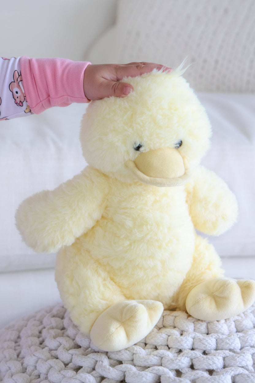 baby with hand on stuffed duck's head 