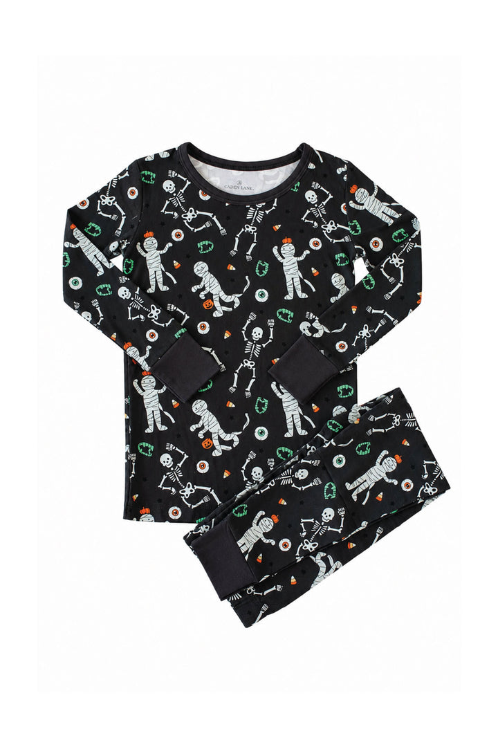 Caden Lane black two-piece pajama set with a white skeleton, mummy, and candy corn print