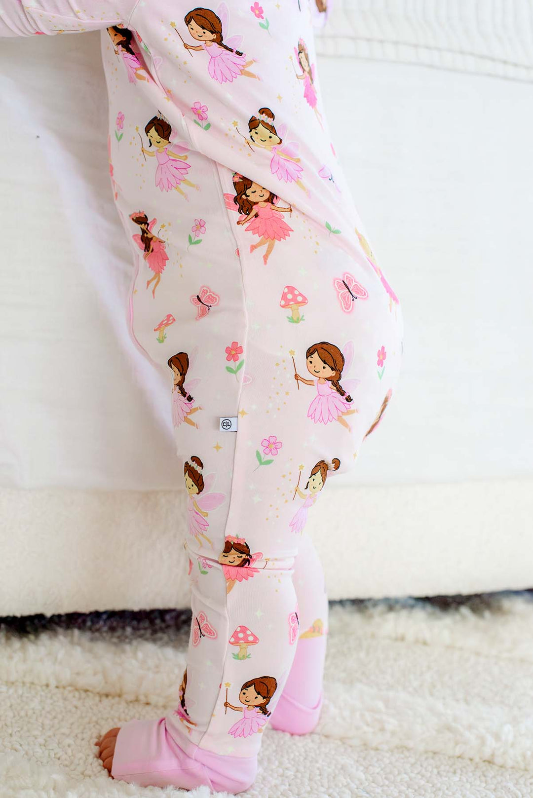 Close-up of the legs of the Fairy Wishes glow-in-the-dark convertible bamboo zip romper showing the fairy print and folded cuffs