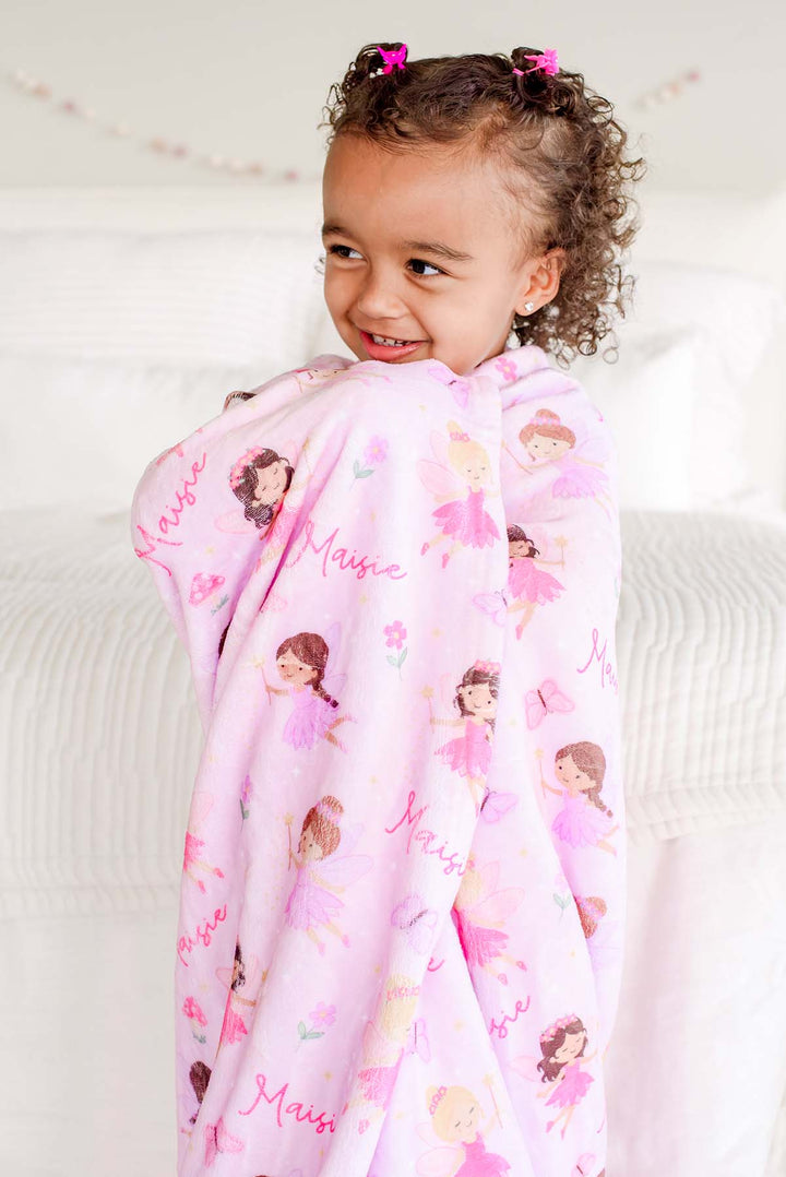 Laughing toddler girl wrapped in the Fairy Wishes personalized kids&