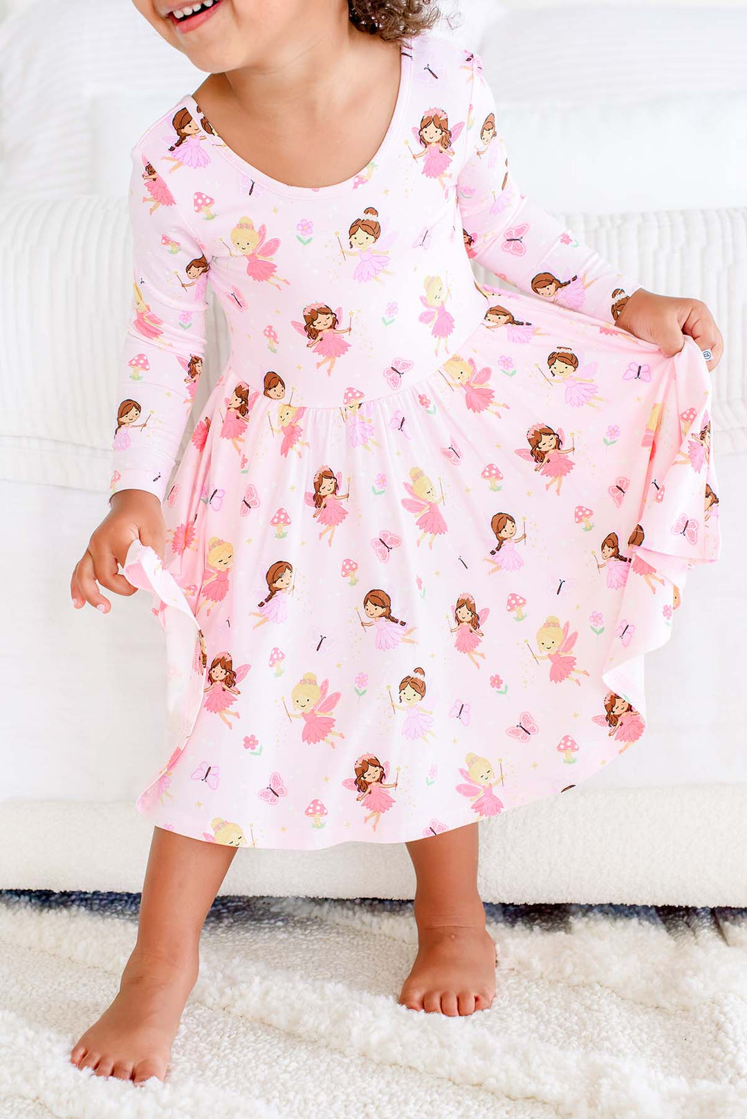 Close-up of the Fairy Wishes long sleeve twirl dress on a toddler, showing the fairy print and flared skirt