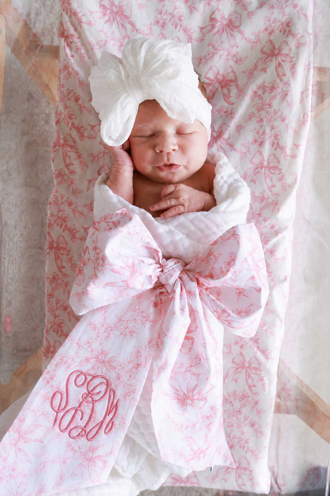 newborn girl wrapped in fancy frills sash