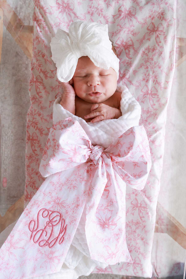newborn girl wrapped in fancy frills sash
