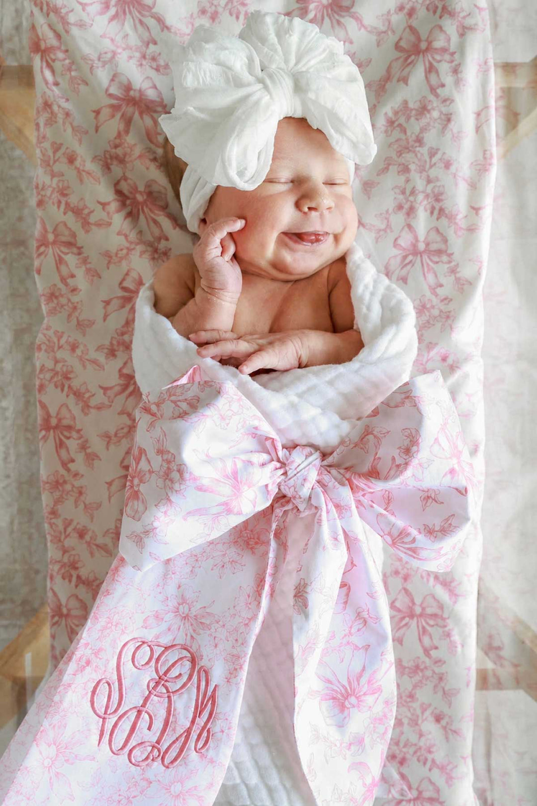 baby girl with tongue out in fancy frills bow sash