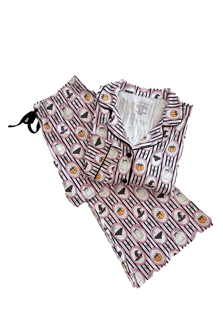 A two-piece pajama set featuring a pink and black striped pattern with circular cartoon-style illustrations, laid flat on a white background.