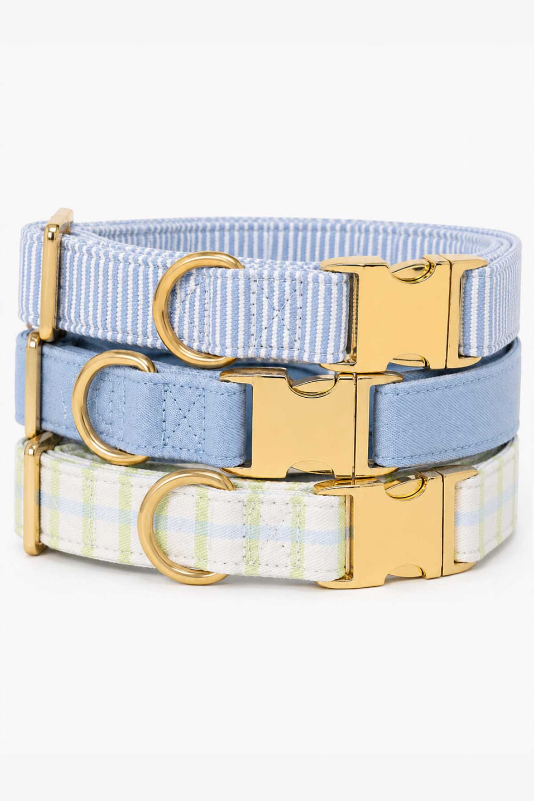 Two Caden Lane dog collars stacked together including a striped fabric collar and a denim days light blue collar, each with gold hardware