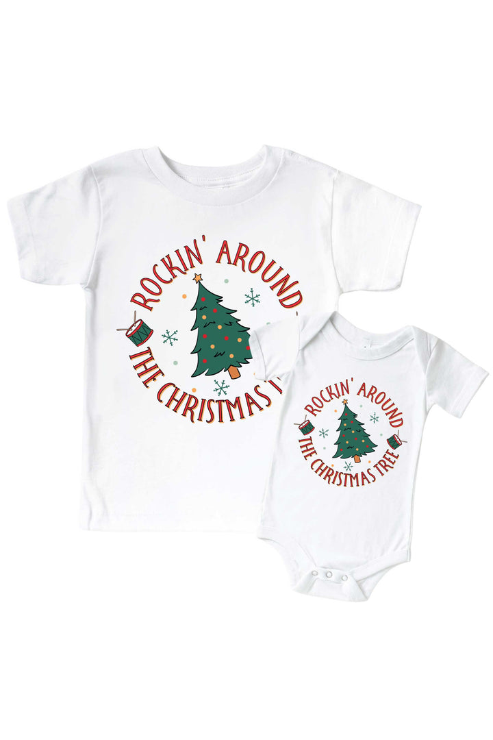 Caden Lane's matching "Rockin' Around the Christmas Tree" t-shirt and onesie featuring a decorated Christmas tree with drums and snowflakes, laid flat together for a sibling set.