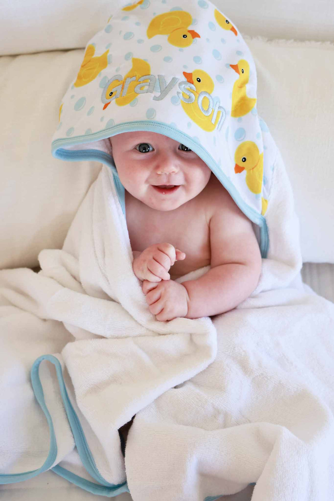 happy baby wrapped in rubber duck hooded towel