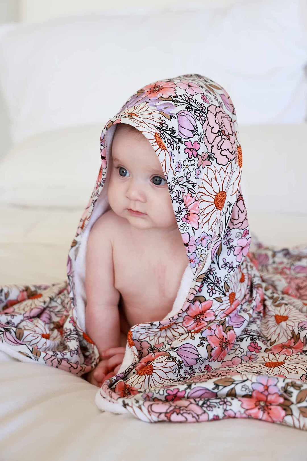 baby girl wrapped in purple floral hooded towel