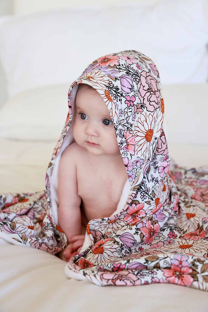 baby girl wrapped in purple floral hooded towel