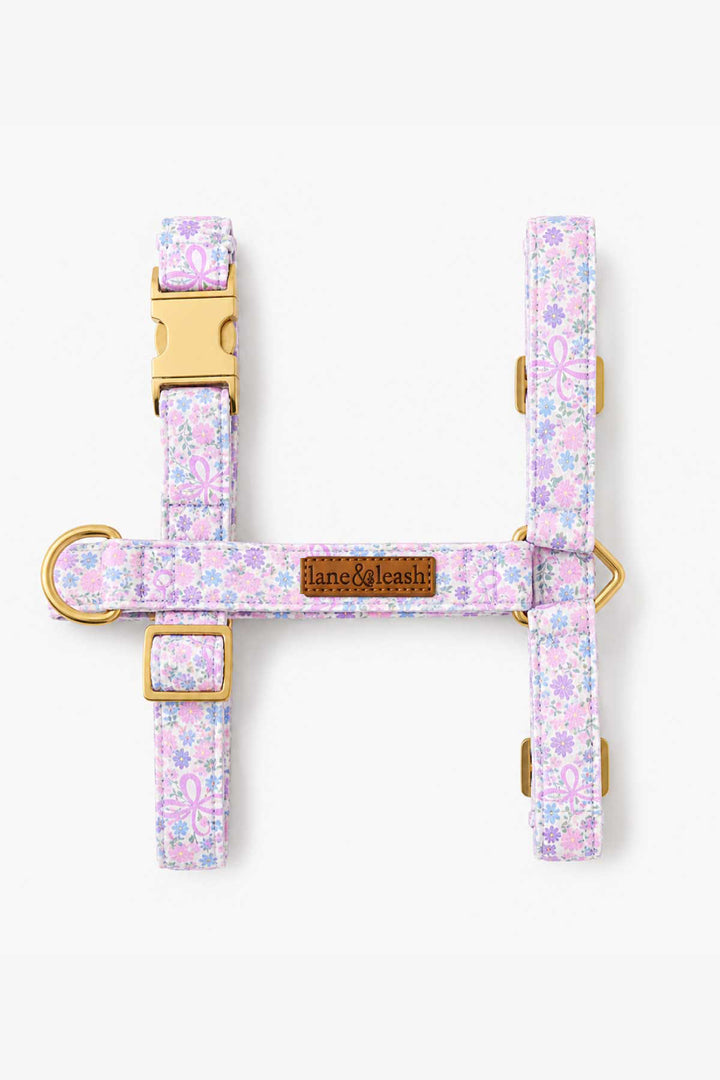 Ribbon Garden strap dog harness laid flat showing the H-shape design in pink and lavender floral print with gold hardware and Lane & Leash brand tag