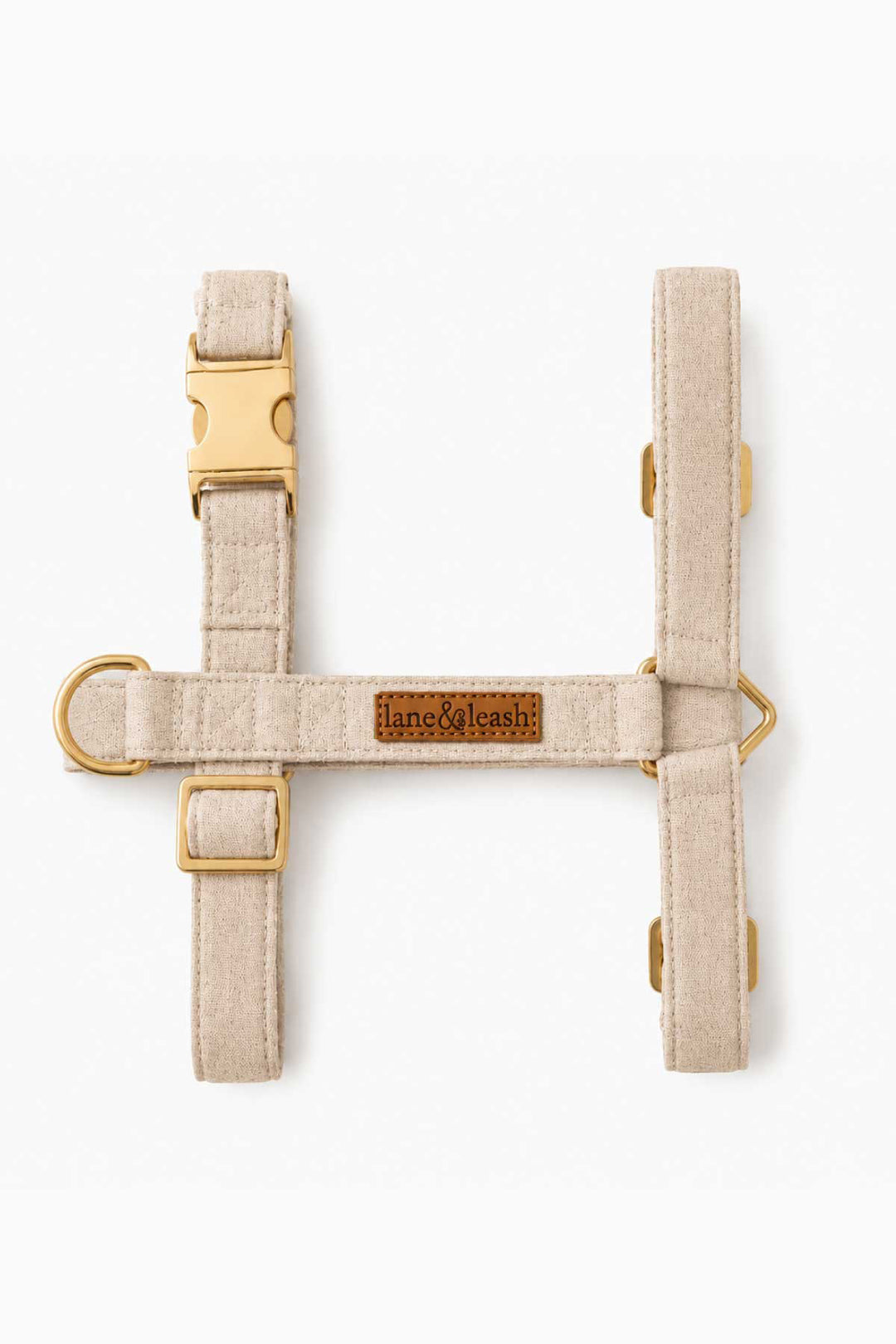 Flat lay of Caden Lane sand dune strap dog harness showing H-style design with adjustable straps and gold D-ring hardware