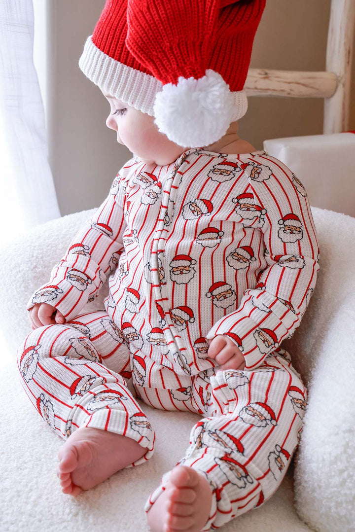 Baby wearing the Caden Lane Holly & Jolly Bamboo Waffle Convertible Zipper Romper in a vintage Santa print, made from soft bamboo viscose with a two-way zipper, perfect for cozy Christmas baby pajamas and matching sibling holiday outfits.