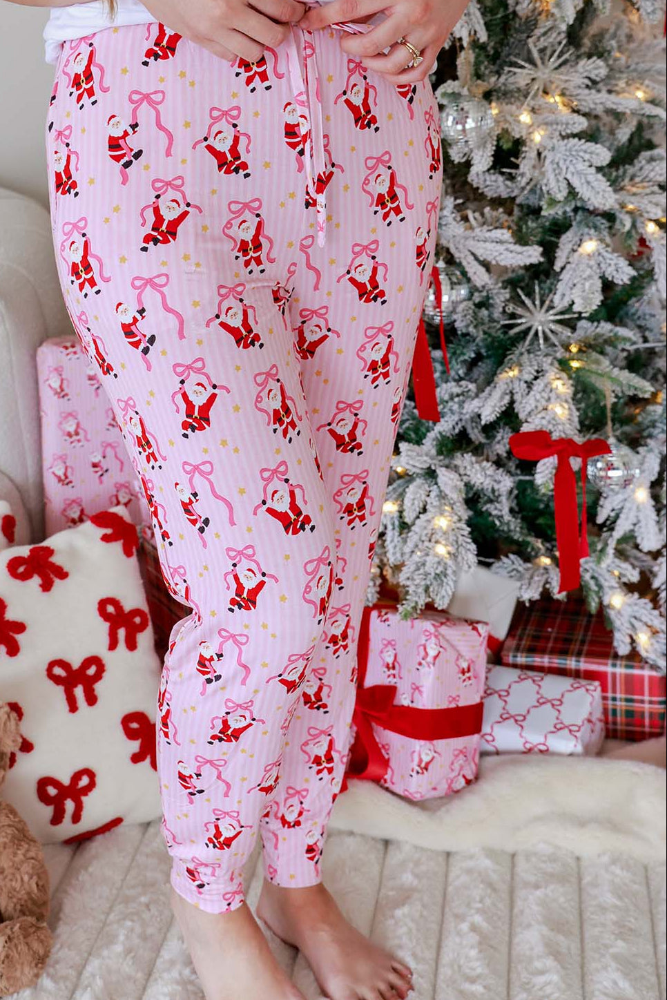 Caden Lane Women's Christmas Jogger Pajama Pants in the Jolly Ribbons print featuring festive Santas, ribbon bows, pink stripes, and buttery-soft bamboo fabric.