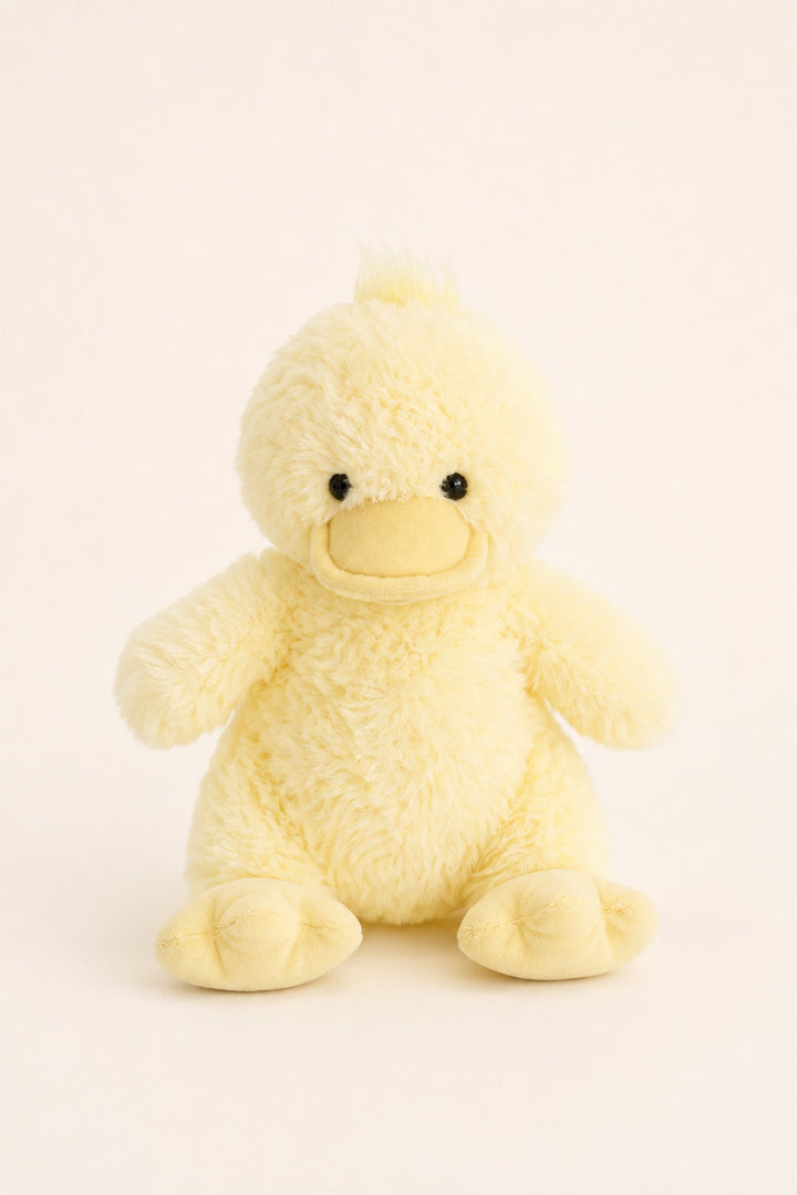 A Caden Lane soft, pale yellow plush duck toy sitting upright against a clean, off-white background.