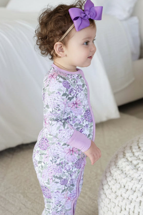 standing baby girl in lavender lullaby convertible zip romper