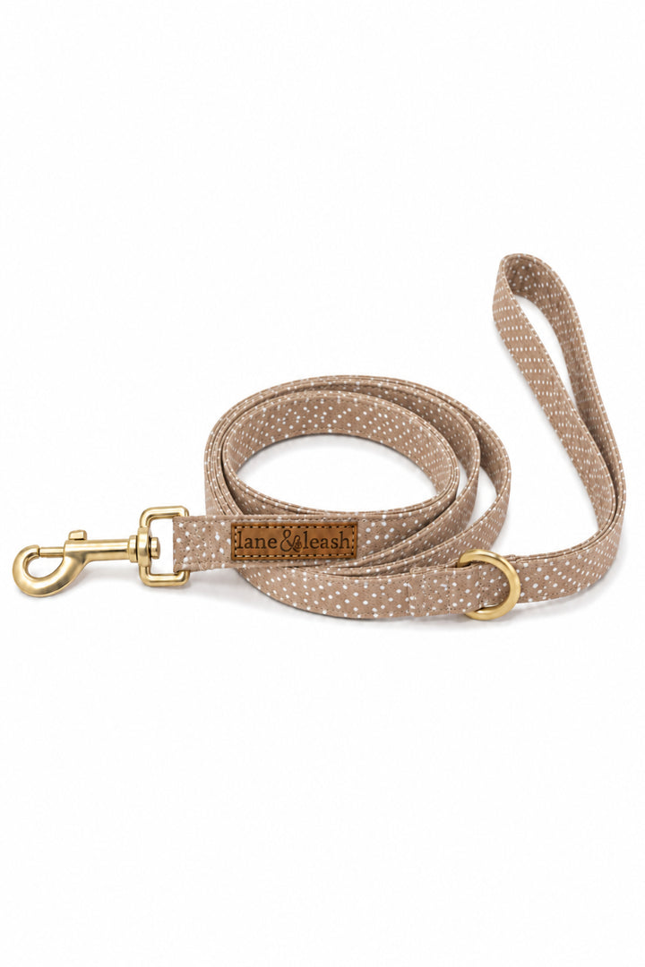 Latte brown polka dot heavy-duty dog leash coiled on a white background with gold swivel clasp and D-ring