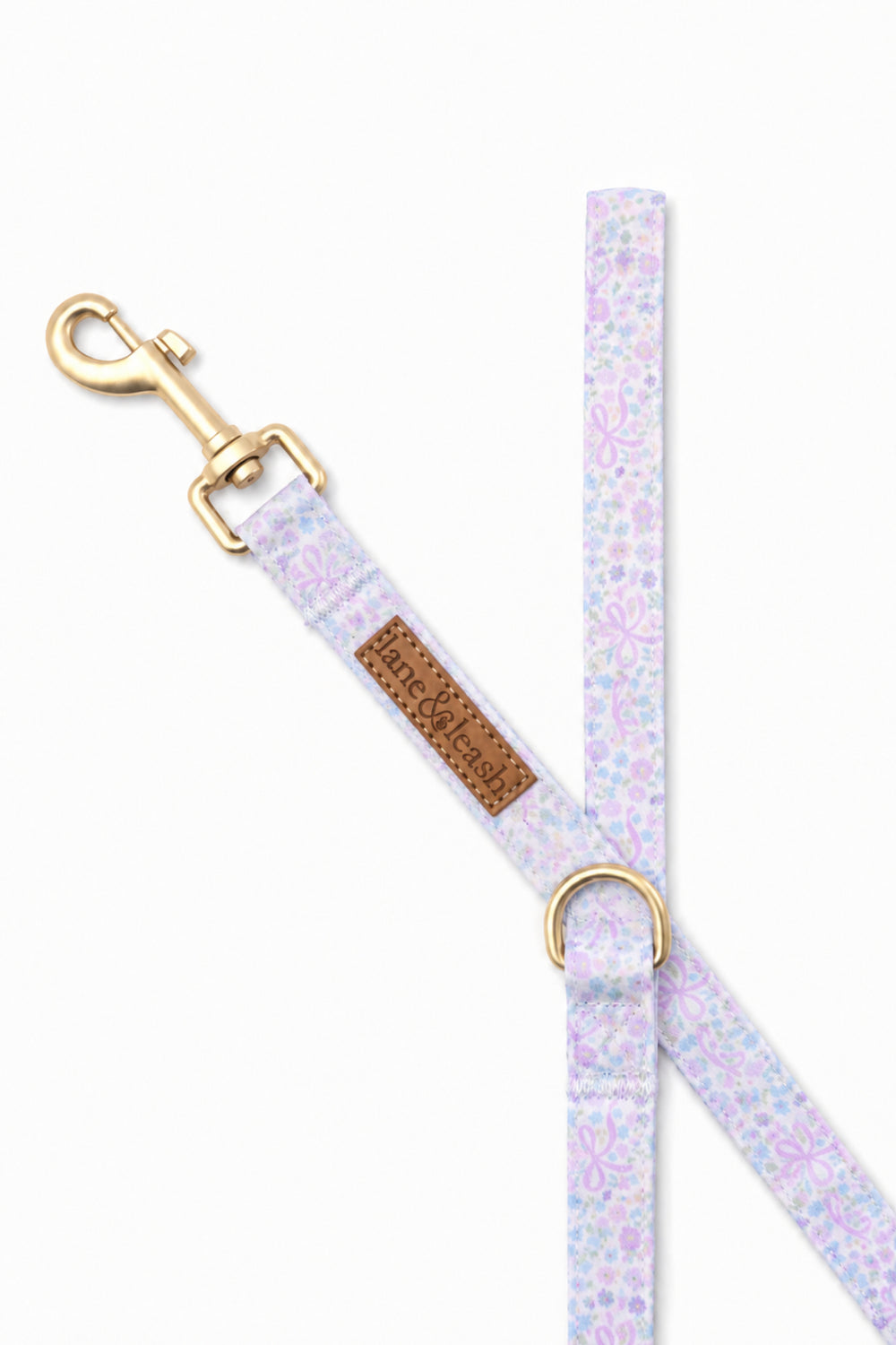 Close-up of the Ribbon Garden dog leash showing the gold bolt snap clasp, Lane & Leash brand tag, and D-ring for attaching accessories, on white background