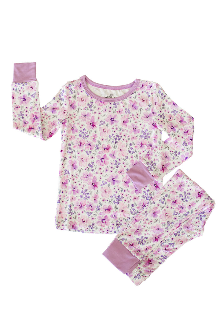 Flat lay of a Caden Lane cream knit two-piece pajama set in a Lilac Dreams print featuring watercolor lilac and pink flowers, with lilac neckline and cuffs.