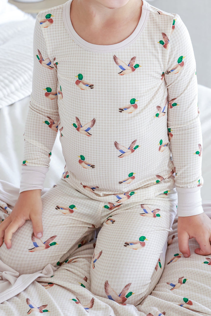 Child wearing little mallard duck print two-piece bamboo pajama set showing the duck print top and pants pattern