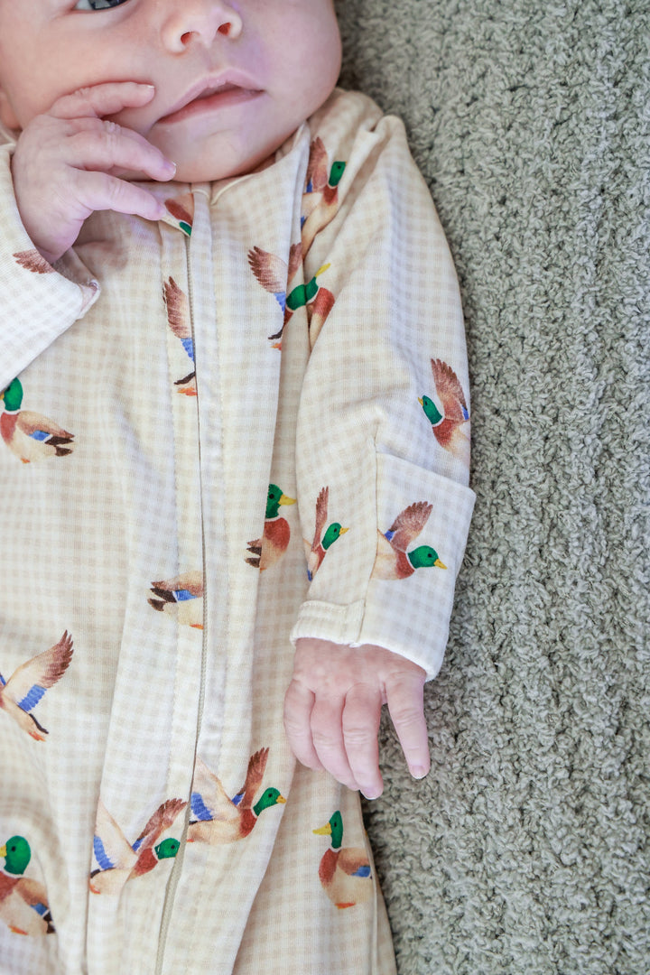 Close-up of newborn baby wearing little mallard duck print bamboo zipper footie showing the large duck pattern on the chest and zipper
