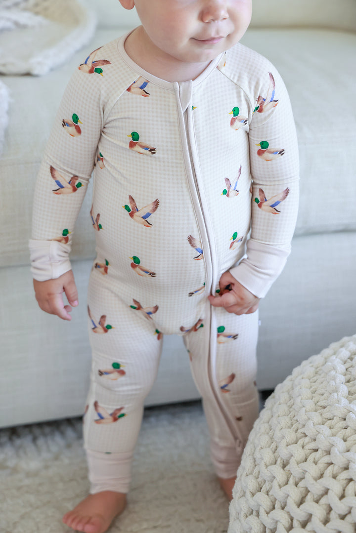 Toddler wearing little mallard duck print convertible zip romper, body view showing front zipper and duck print pattern