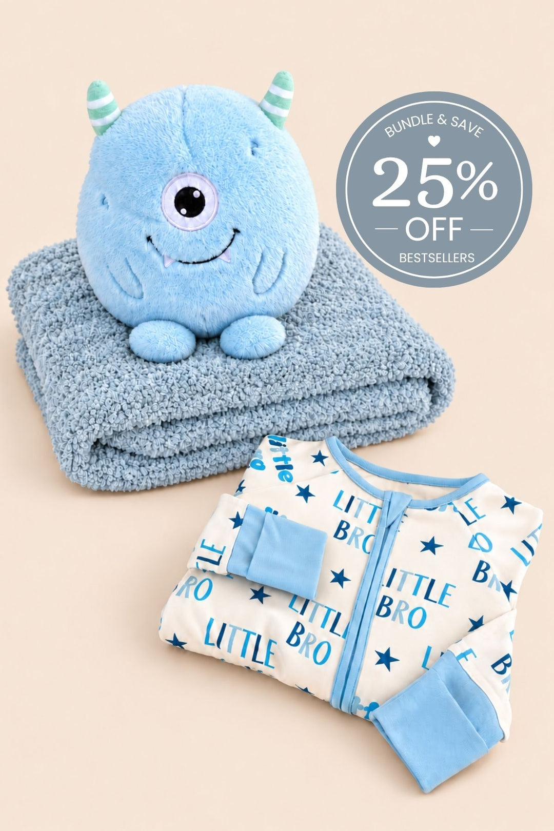 Hanger shot of a Caden Lane white bamboo convertible zip romper in a Little Bro print featuring blue lettering and stars, paired with a monster plush on a slate blanket.