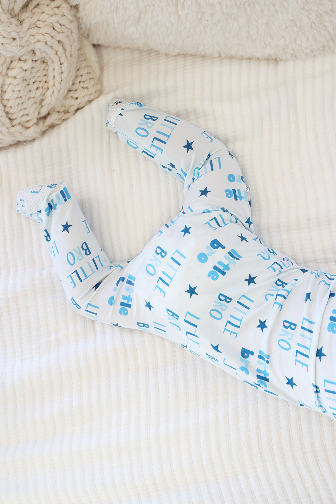 baby boy laying on stomach wearing blue little bro star zipper footie 