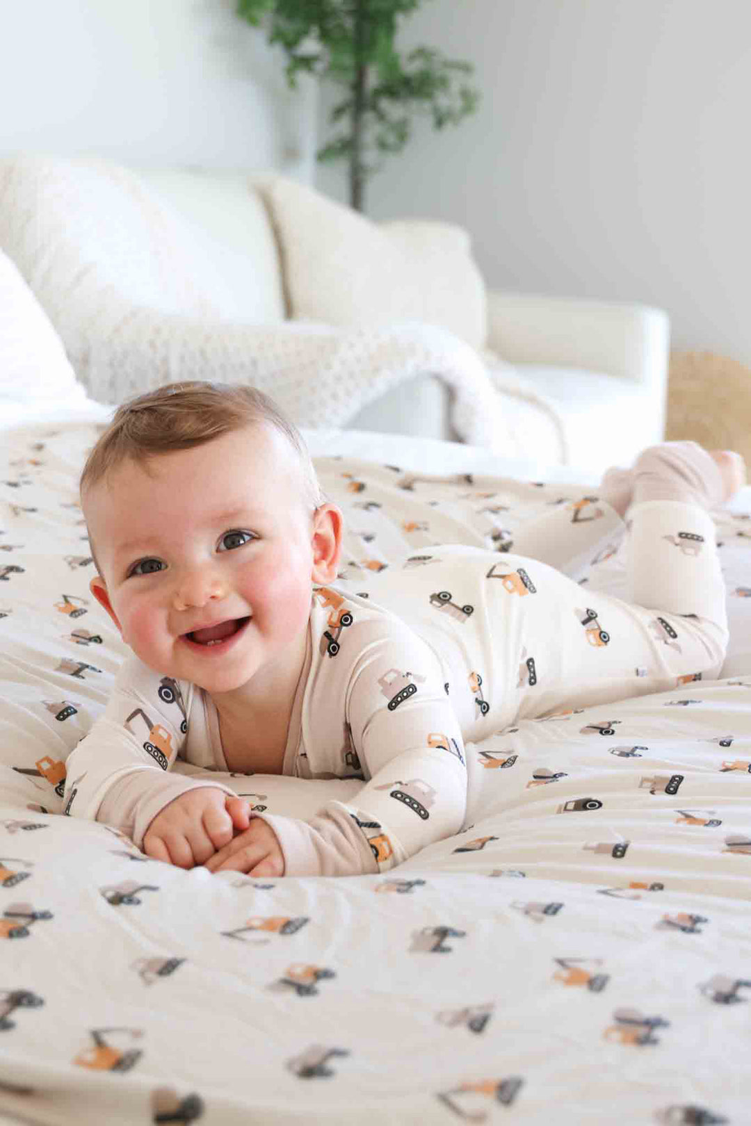 baby boy laying on stomach in little builder convertible zip romper
