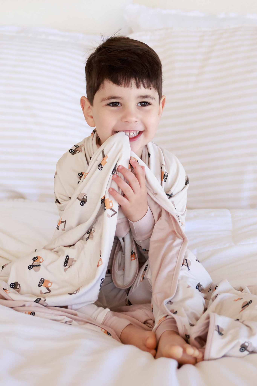 sitting boy with little builder bamboo blanket wrapped around him 