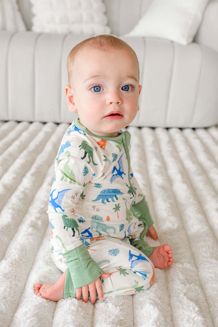 kneeling baby boy in little fossil neutral convertible zip romper