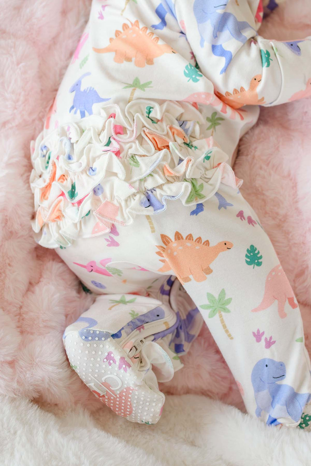 ruffle bottom zipper footie for baby girls in pink little fossil print 
