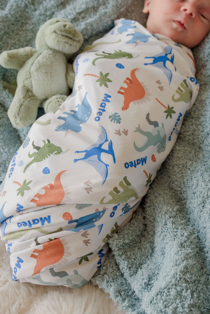 baby boy wrapped in colorful personalized swaddle blanket 