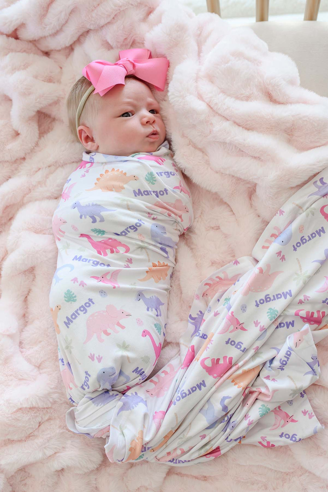 baby girl swaddle blanket with pastel dinosaurs with pink ribbon bow headband 
