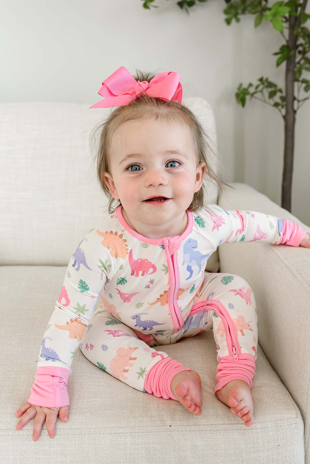 smiling girl in little fossil pink convertible zip romper 