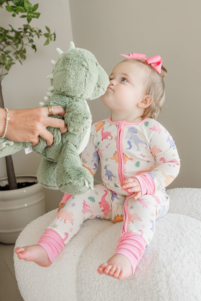girl kissing stuffed dinosaur in little fossil convertible zip romper 