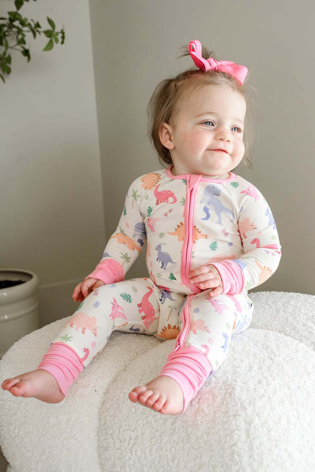 smiling baby girl in little fossil pink convertible zip romper 
