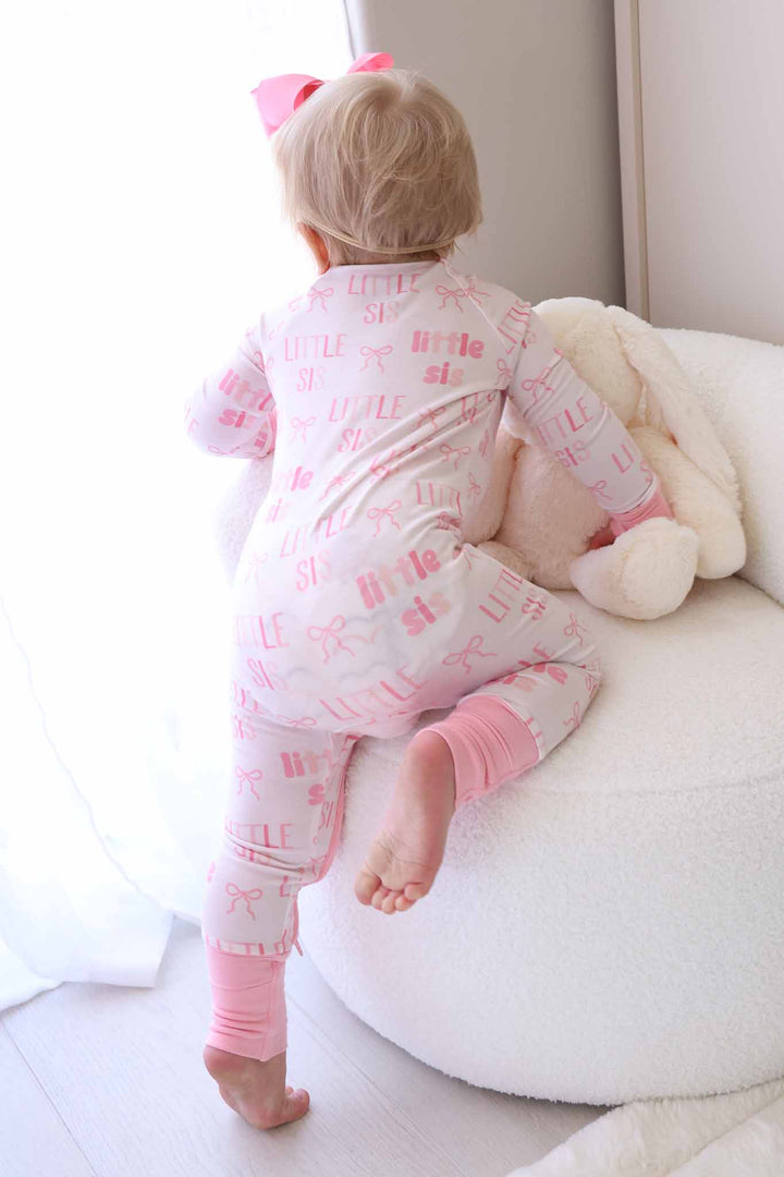 girl climbing up on chair in pink little sister bamboo convertible zip romper 
