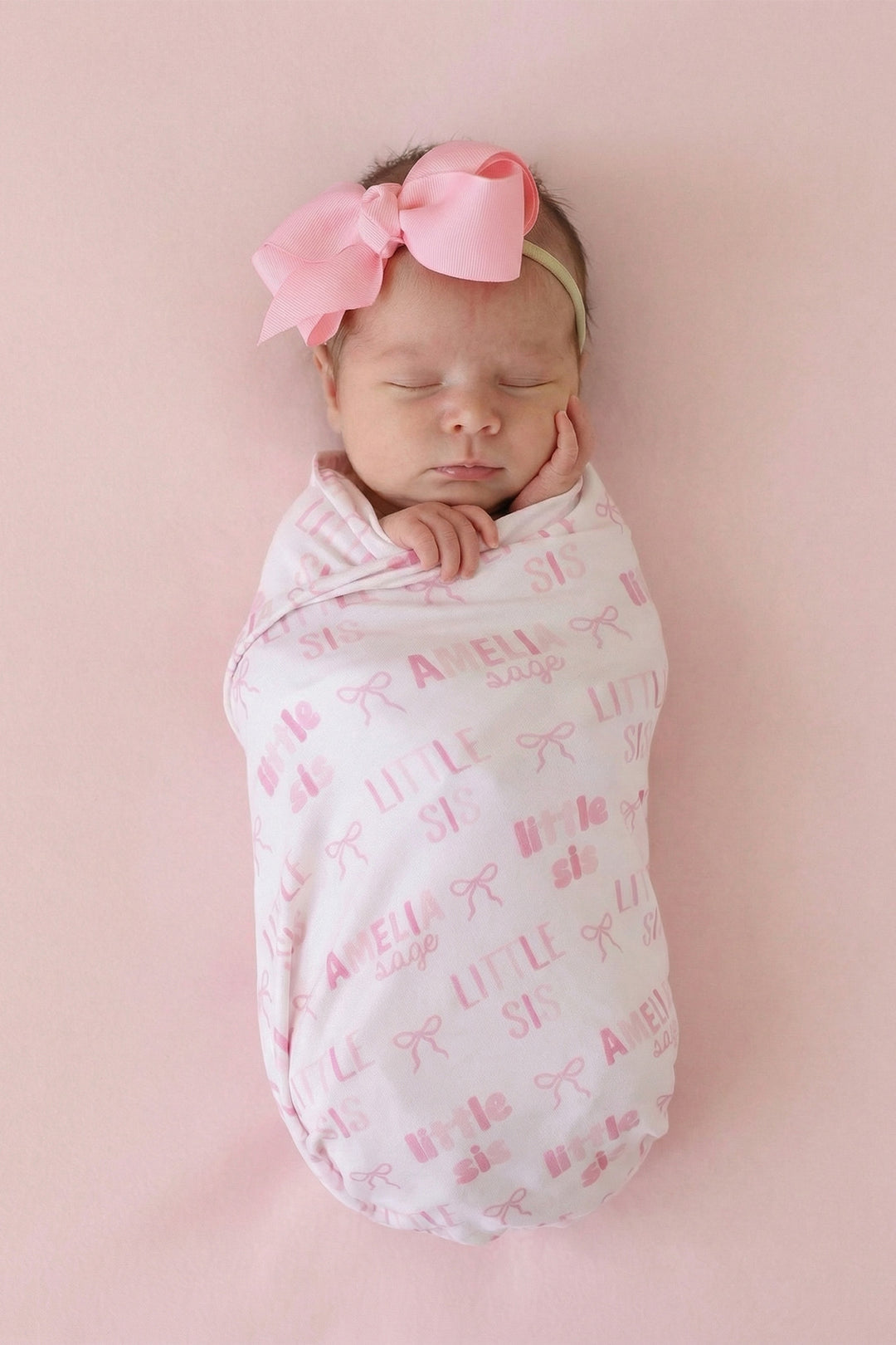 baby girl wrapped in little sis personalized swaddle blanket with pink bows