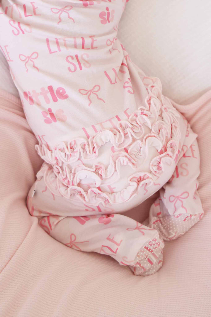 little sis bow ruffle zipper footie pajama in block letters and different shades of pink 