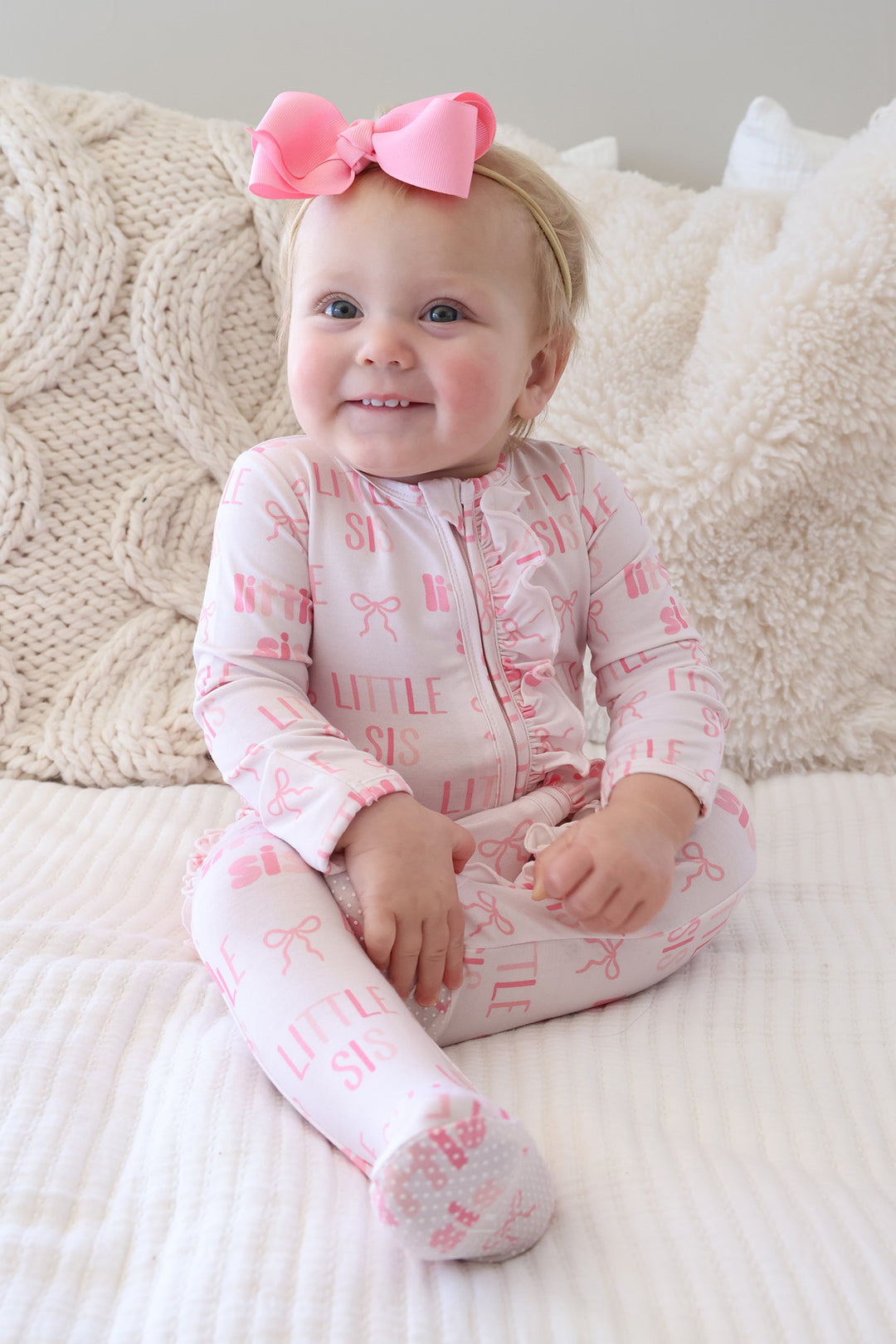 little sister ruffle footie pajama for baby girls with a matching pin ribbon bow headband 