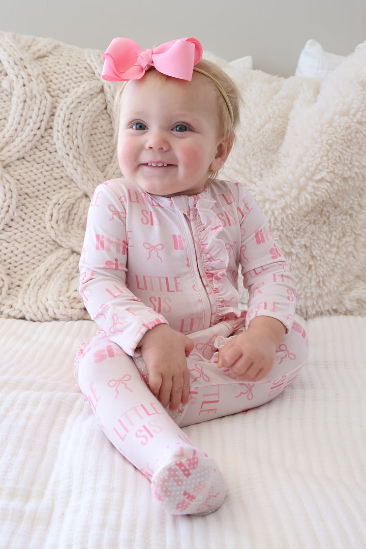little sister ruffle footie pajama for baby girls with a matching pin ribbon bow headband 