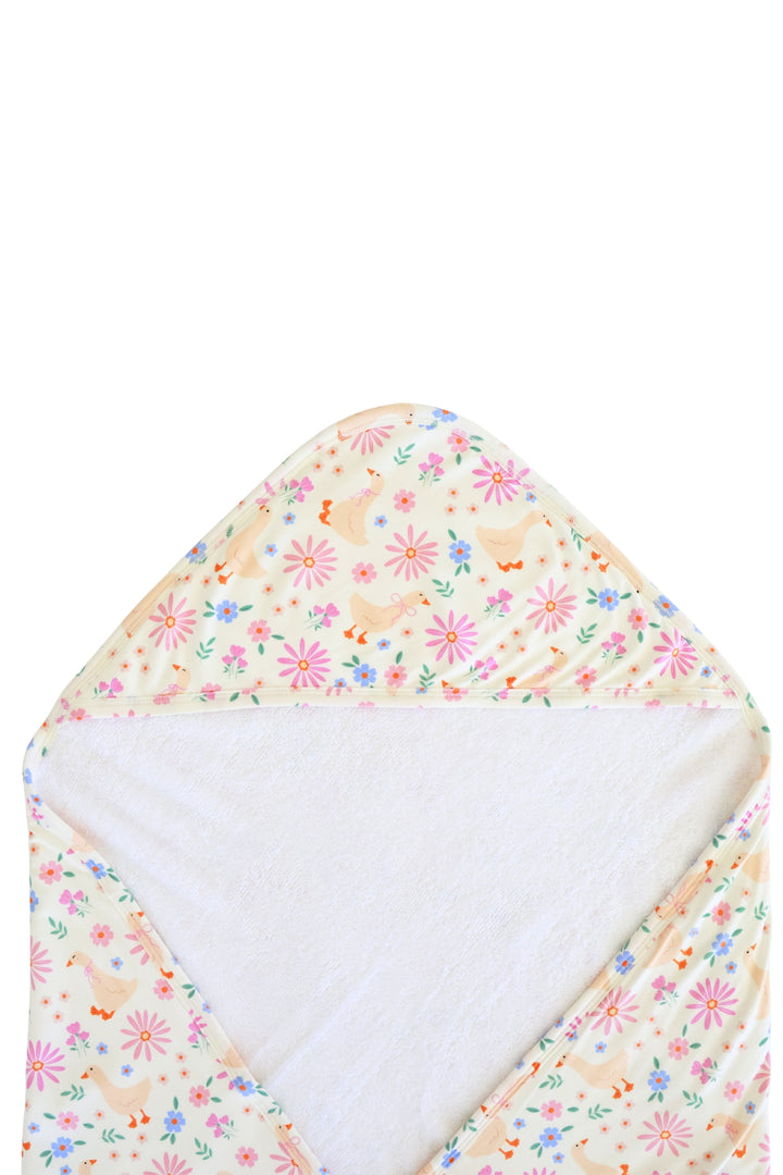 Lucy Goosy Embroidered Bamboo Hooded Towel laid flat and open from above, showing the exterior duck and floral print pattern with white terry cloth interior on a white background