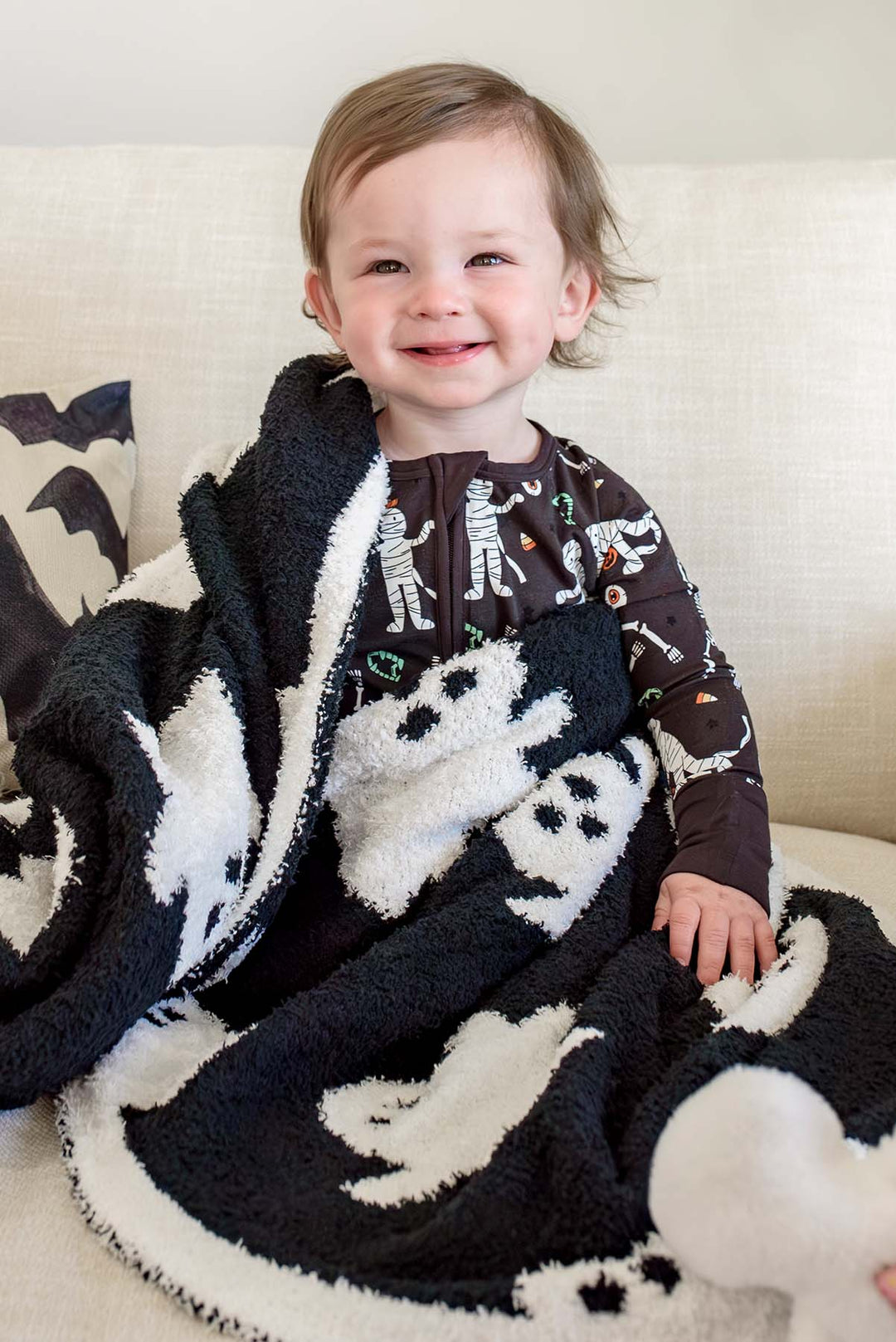 boy wrapped in ghost cuddlelane reversible blanket 