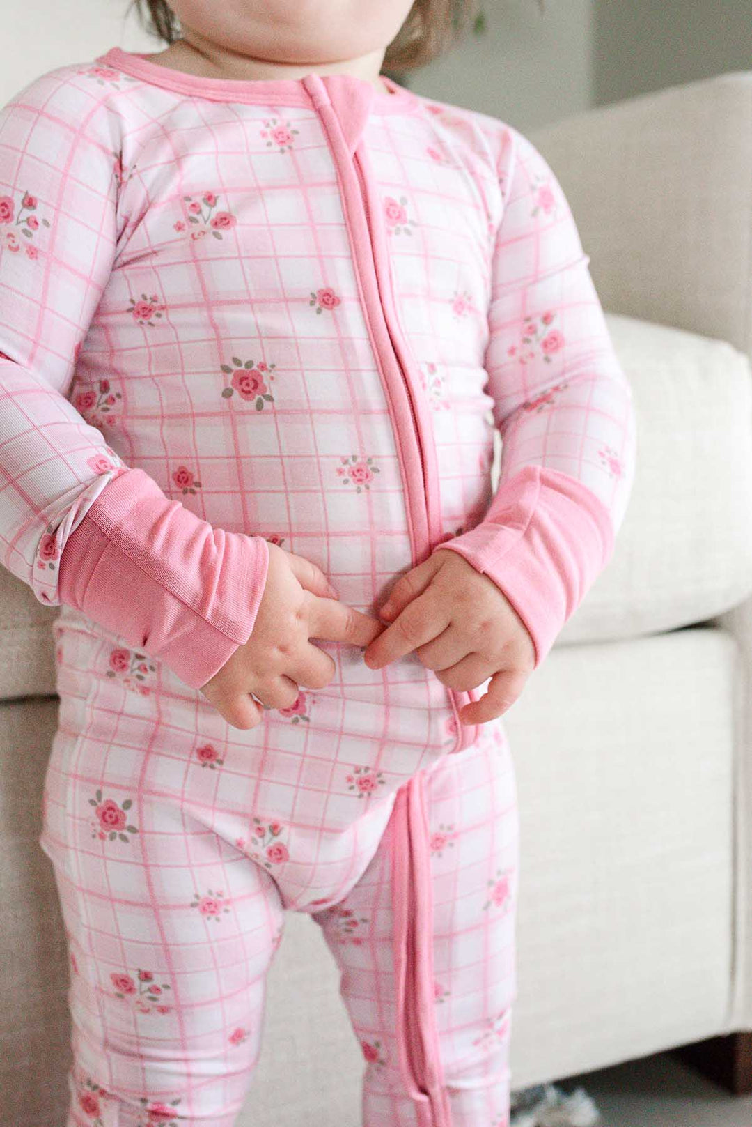 Close-up of zip closure and rose print on toddler romper