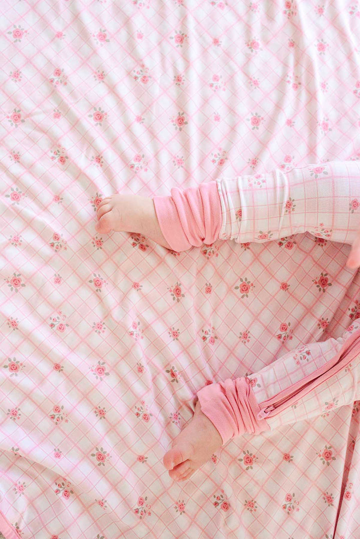 Close-up of toddler feet on Primrose Plaid blanket on bed