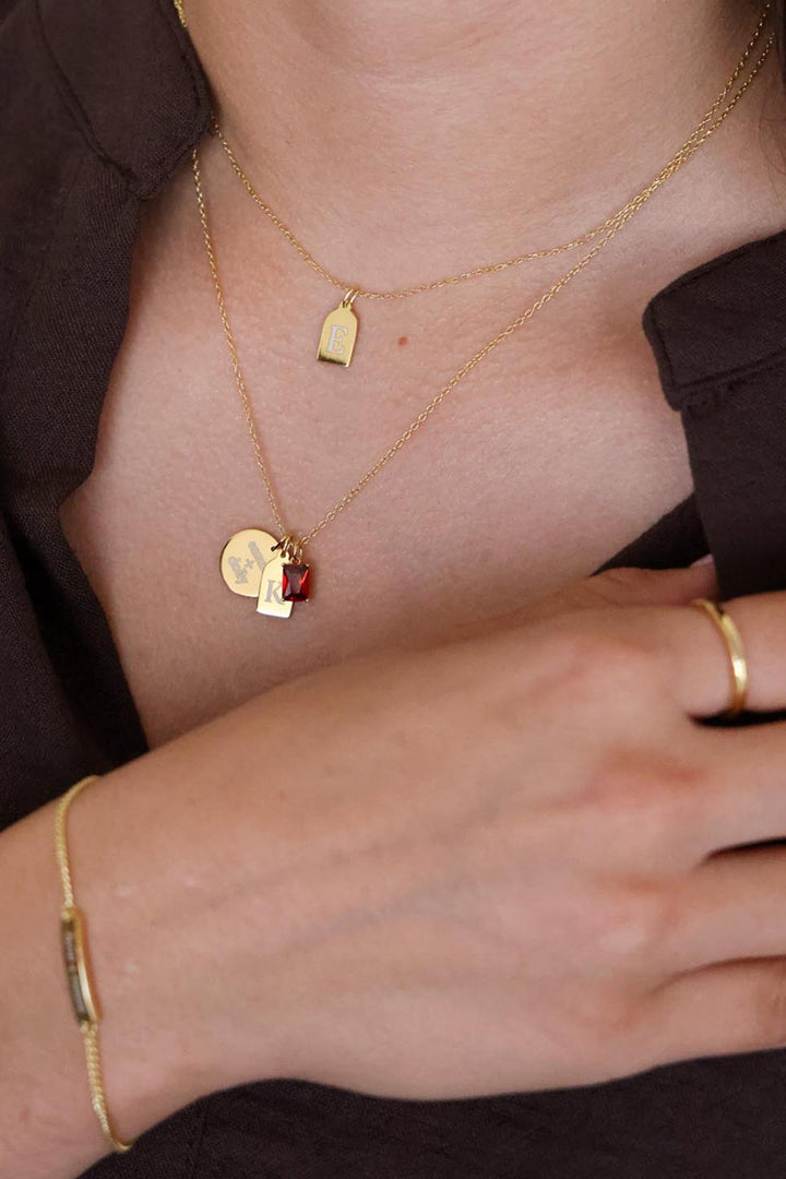 stacked engraved charm gold necklace with january birthstone 