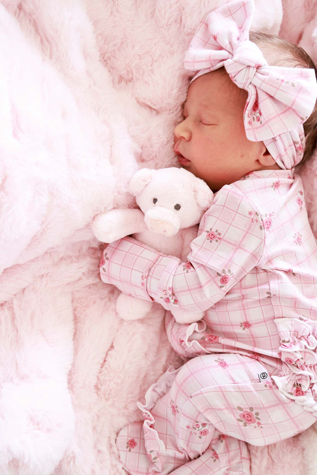 Sleeping baby wearing Primrose Plaid headwrap and pajamas with teddy bear