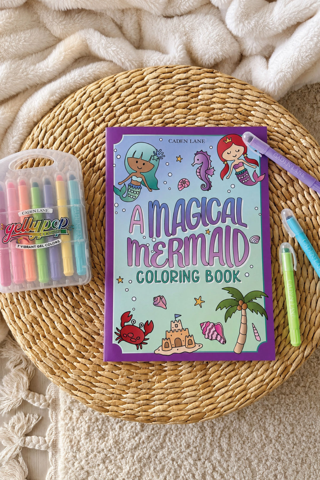 Caden Lane "A Magical Mermaid" coloring book styled with Gellypop gel crayons on a woven tray.