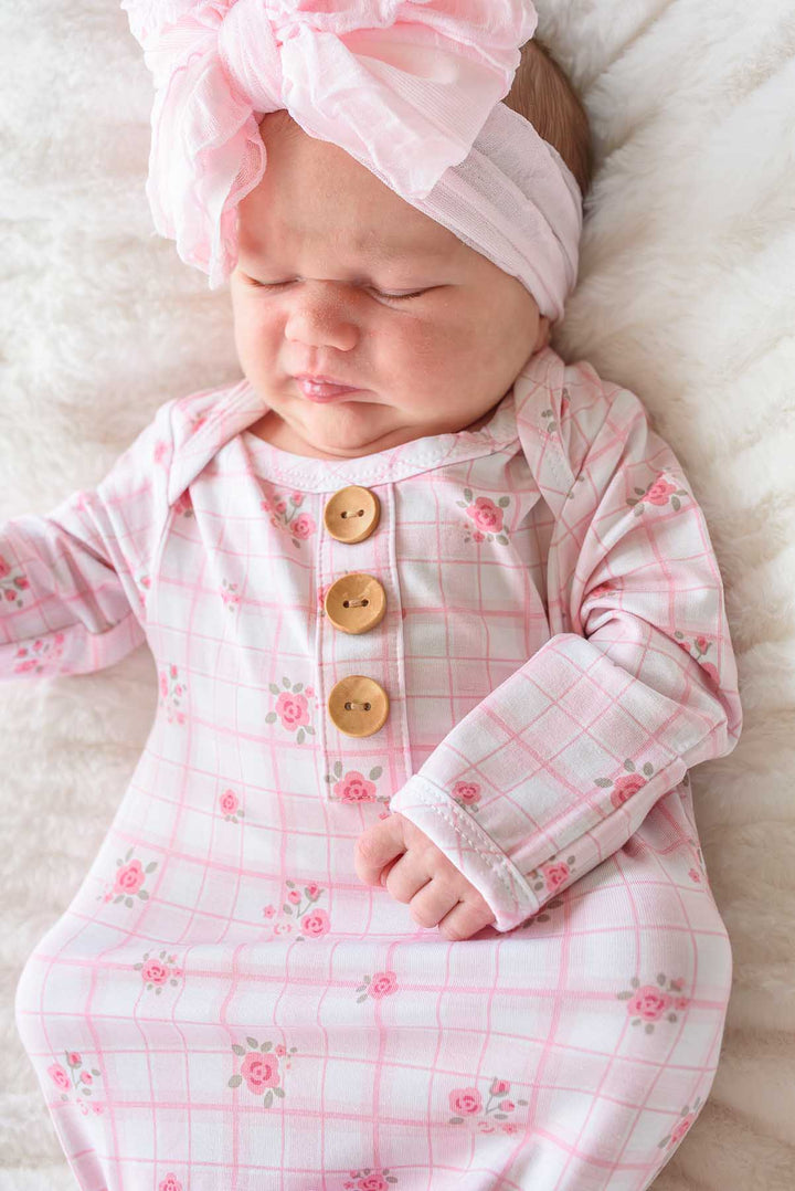 Awake baby wearing Primrose Plaid knot gown and pink bow headwrap